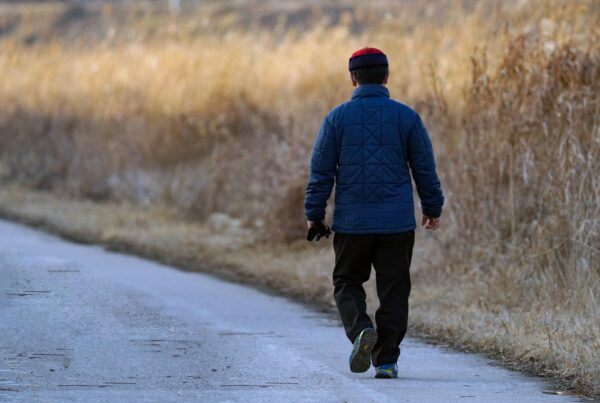 Alcohol Rehab, man walking away from camera in a field